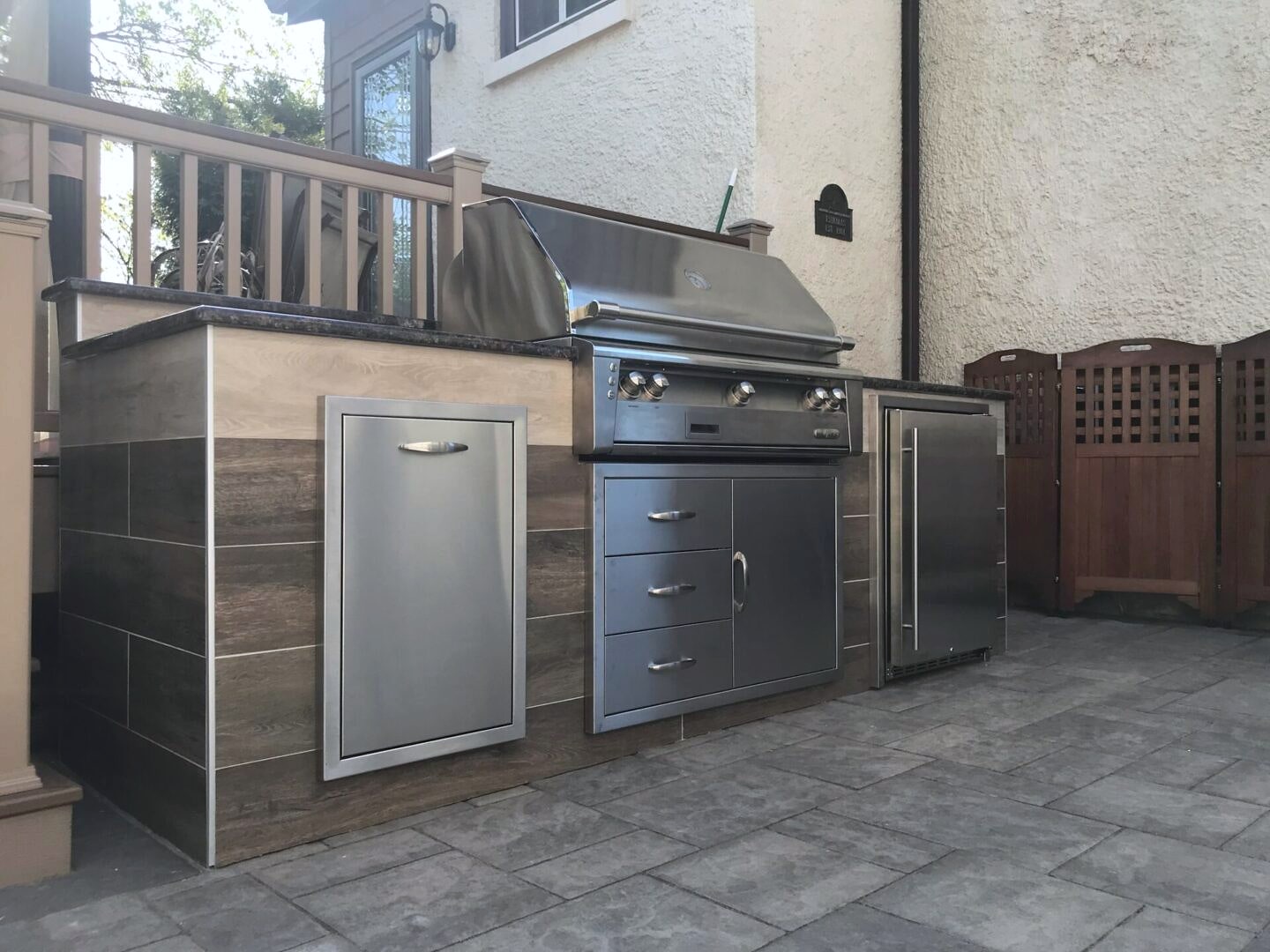 Paver patio with built-in stone grill station and herringbone inlay